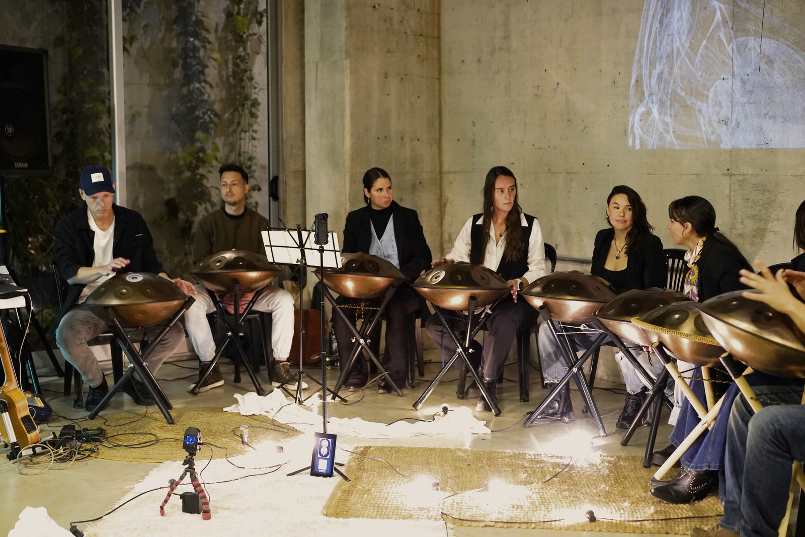 Los ocho handpans en fila con velas en el piso